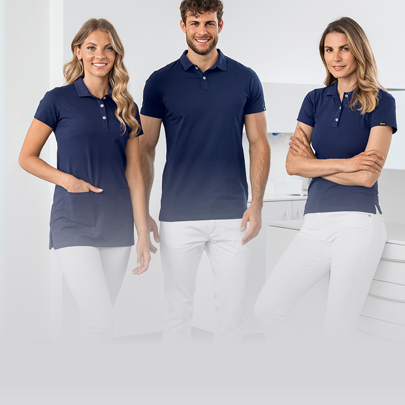 Ein Mann und zwei Frauen in blauen Poloshirts in einer Praxis